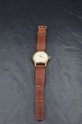 A gent's 1950's 9ct gold wrist watch by Smiths having Arabic numeral dial to decorative face in a