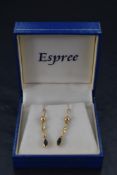 A pair of Artisan made yellow metal earrings having loop fittings with diamond set terminals to