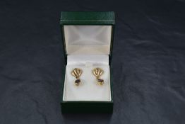 A pair of 9ct gold stud earrings having moulded fan style terminals with blue tear drop drops,