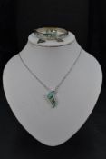 A silver and faux opal four piece jewellery suite comprising of pendant, earrings, ring and