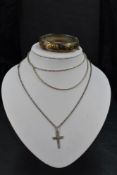 A silver hinged bangle having engraved floral and scroll decoration, a silver cross and chain and