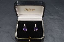 A pair of 18ct white gold stud earrings having collared diamond studs with further diamond connector