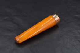 A cased amber cigar holder having 9ct rose gold collar