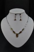 A silver and faux black opal articulated necklace having five opal panels with fixed oblong link