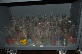 A large quantity of vintage glass milk bottles, with advertising, including 'S.Anderton & Son of