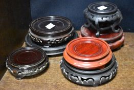 A selection of wooden oriental vase stands, some carved.