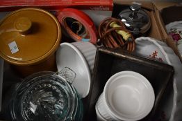 A carton of kitchen themed items including a butter dish in the form of a cow, a cast iron cooking