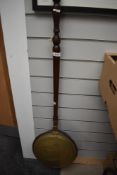 A traditional copper and brass warming pan having mahogany handle