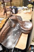 A leather saddle, of traditional design applied with two 'DHS' buttons