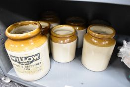 A selection of vintage buff stoneware storage jars, seven in total, the larger retaining the