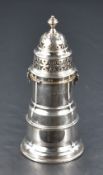 A George V silver sugar sifter, of traditional design with pierced finial topped twist-off cover