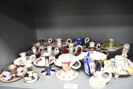 A collection of vintage ceramic candlesticks, including Staffordshire and one bearing crossed swords