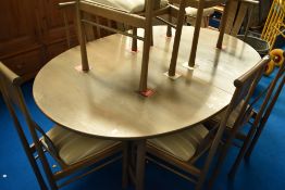 A modern Ercol dining suite comprising table and eight dining chairs