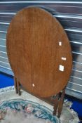 An oak occasional table having oval top, with folding frame, approx. 92 x 75cm