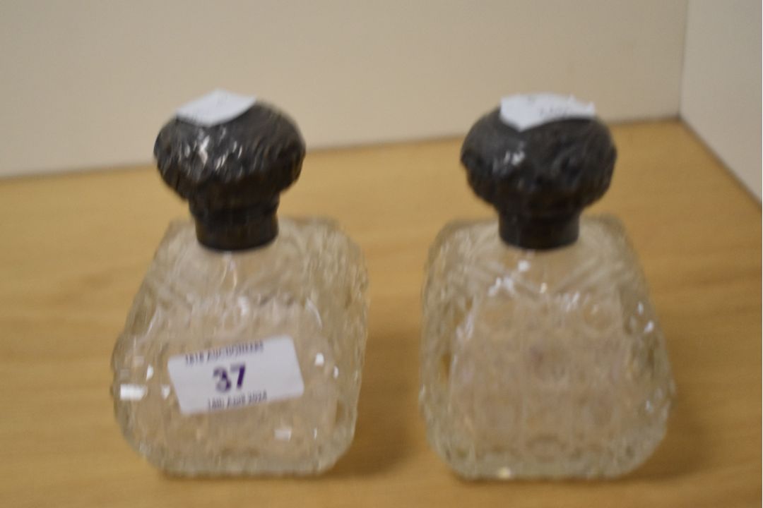 A pair of Edwardian cut glass scent bottles, having Walker & Hall silver lids hallmarked for - Image 1 of 2