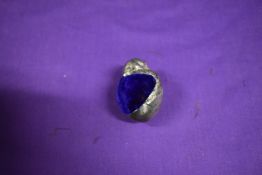 A white metal pincushion in the form of a chick, having iridescent blue/cerise velvet to top.