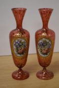 A pair of late 19th/early 20th Century Bohemian glass vases, decorated with vignettes of floral