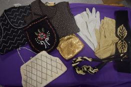 A selection of vintage evening bags, two 1960s tank tops, two pairs of gloves and two belts.