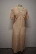 A 1930s / 1940s peach nightdress with lace and appliqué detail to bodice and tie fastening to waist,