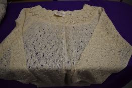 An assortment of vintage items, to include two jumpers, two aprons and a hat.