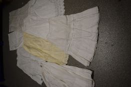 A large collection of Victorian to early 20th century petticoats and aprons, many with intricate