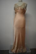 An Art Deco pale pink bias cut nightdress, having beautiful lace to bodice and hem, tie fastening to