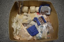 A collection of lace and crochet thread, hooks, buttons, collar and lace.