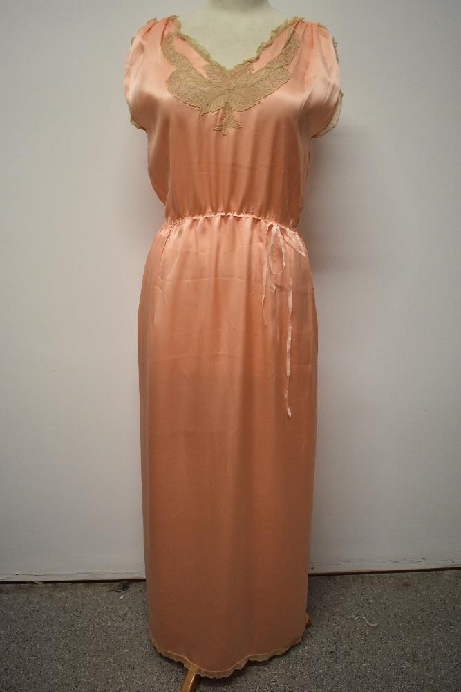 A 1920s pale pink silky 1920s nightdress, having adjustable ribbon fastening to waist, pretty lace