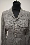 A fine dog tooth patterned 1950s day dress, having faux bolero effect to bodice, full length sleeves