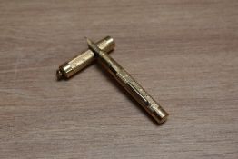 A Mabie Todd & Co Swan lever fill fountain pen in engine turned gold with ring top cap having