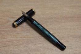 A Pelikan M400 piston fill fountain pen in green striped with black cap having Pelikan 14C 585 F