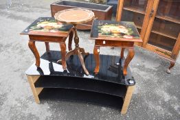 A modern laminate and glass TV stand and three occasional tables