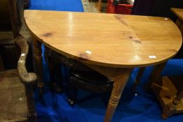 A natural pine demi lune hall table on turned legs, width approx. 102cm