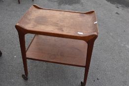 A vintage teak tea trolley having removable tray top