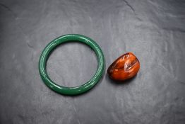 A vintage green glass bangle (with old repair) and a rough cut (polished) Baltic Amber pendant, no