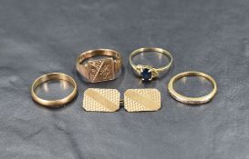 An assortment of gold rings comprising a sapphire solitaire with pierced heart motifs to the