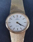 A ladies 9ct gold wristwatch by Omega, the champagne dial with baton five minute markers on a
