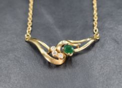 An 18ct gold necklace having a moulded central panel with diamond and emerald decoration on a