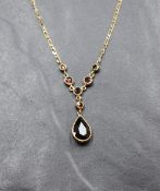 A 9ct gold and garnet necklace having collared stones with teardrop drop and fixed chain, approx 16'