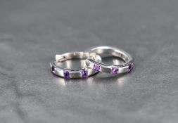 A pair of 9ct white gold hinged hoop earrings having amethyst insets, approx 5.3g