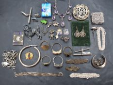 A selection of silver and white metal jewellery including charms, brooches, chains, rings, necklaces
