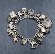 A silver curb link charm bracelet with a silver heart padlock, having sixteen white metal charms