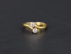A diamond cross over ring having two diamonds, each approx 0.25ct in claw set mounts to cross over