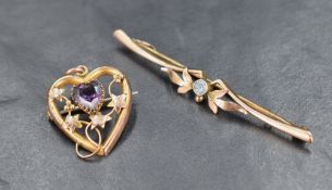 A 9ct gold openwork heart shaped brooch, having a central heart shaped amethyst surrounded by a vine