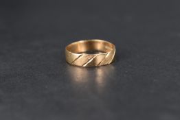 A 9ct gold wedding band having brushed and cut decoration, size T & approx 2.1g