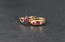 Two ruby rings, one having a seven ruby floral design with openwork circular shoulders, missing