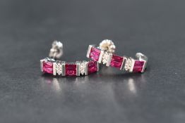 A pair of 18ct white gold half loop stud earrings having alternate pairs of rectangular facet cut