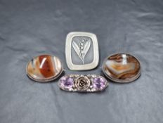 Four silver and white metal brooches comprising a white metal lily of the valley brooch signed R