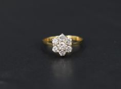 A diamond daisy cluster ring, total approx 0.5ct in a raised claw mount to knife blade shoulders