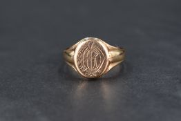A 9ct gold signet ring, having a monogram engraved to the oval face with tapering shoulders, ring